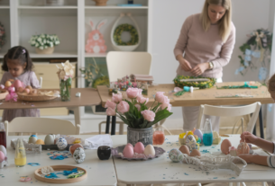 Dollar Tree Easter Crafts: An Easter egg decorating station with kids decorating eggs and craft table with Easter wreaths in process of being made by their mother.