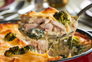 Creamy, cheesy easy low carb chicken casserole recipe showing a serving spoon lifting a spoonful of creamy cheesy casserole from the serving dish.